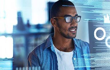 Image of a person looking at computer code on a monitor.